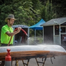 A person sprays off the bottom of a boat.