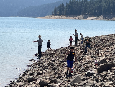 Children fishing at a reservoir on a summer day