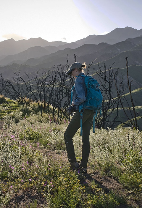 A woman standing in front of a scorched mountainside