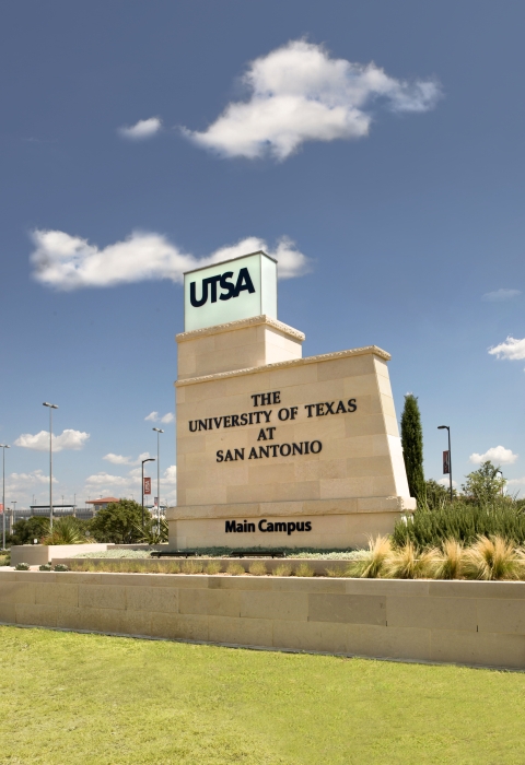 The main campus sign for the University of Texas at San Antonio is pictured in front of a blue sky.