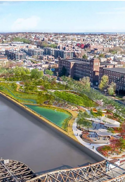 An aerial view of a city with a green park near the water