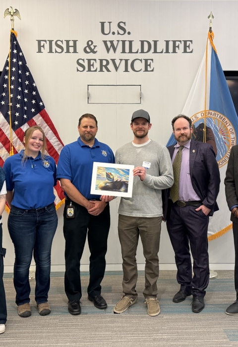 2024 National Junior Duck Stamp Art Contest judges holding the winning artwork