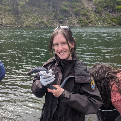 Sylvia holding an adult Pacific Lamprey during a release event.