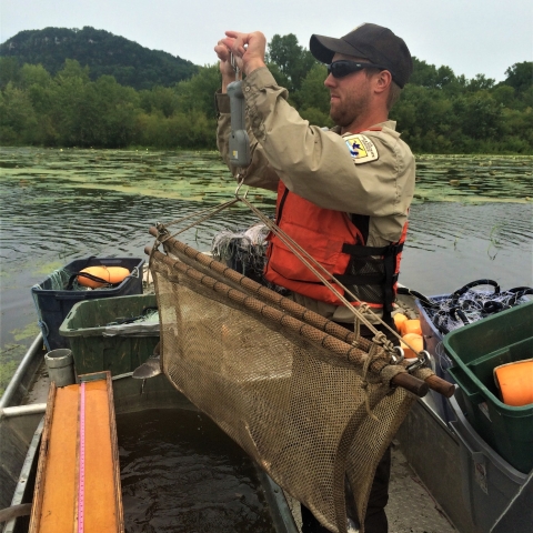 Person holding up net while on boat.