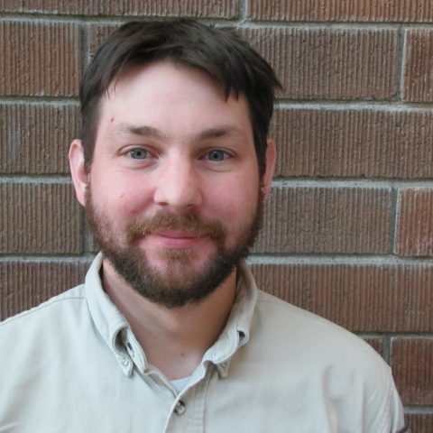 Man in FWS uniform with brick wall behind him.