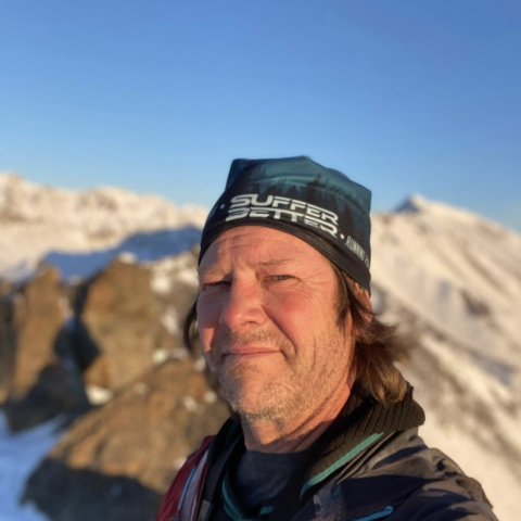 man in a hat on a snowy mountain