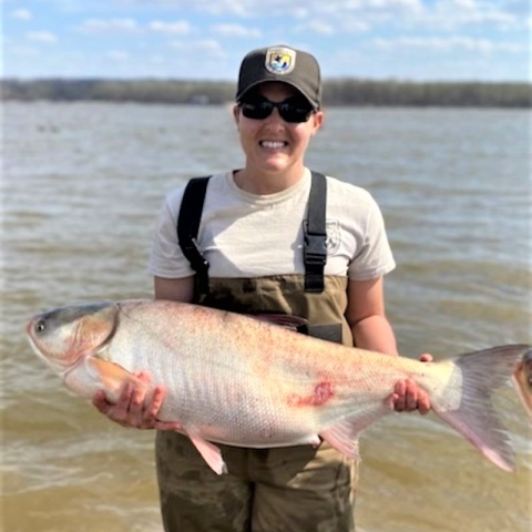 Woman smiles while holding carp