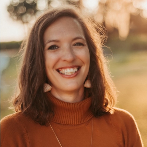 Kelly smiling in a turtleneck