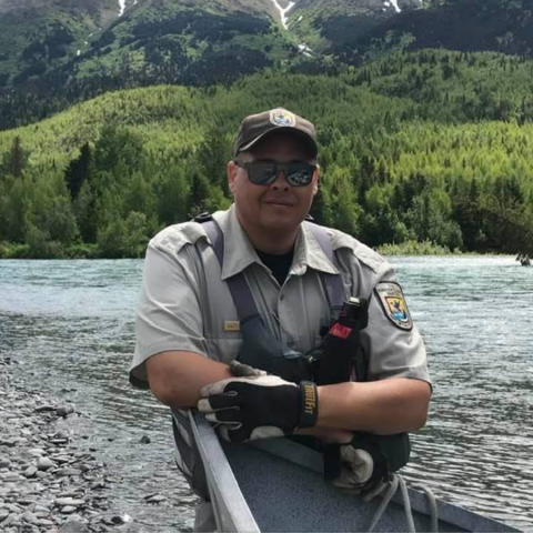 Man in uniform stands by a river