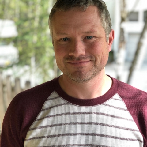 man outside in a striped shirt