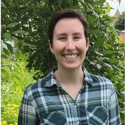 Rachel smiles in a blue and black flannel