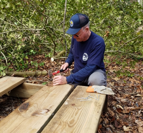 A volunteer helps build a well cover