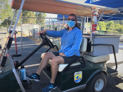 A USFWS volunteer drives a golf cart carrying fertilized spring Chinook salmon eggs from the spawning area to the nursery.