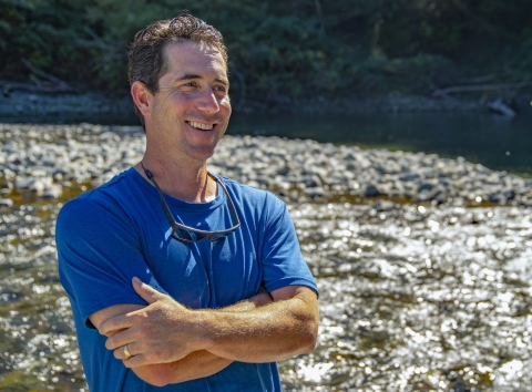 a man standing next to a river