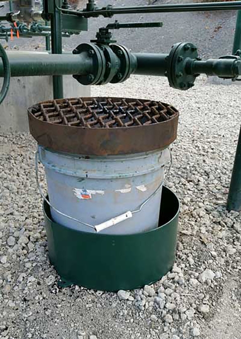 A pale blue bucket with a metal grate over the top