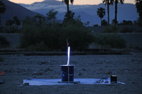 Nighttime shot of a stand with a beaming light sitting on ground