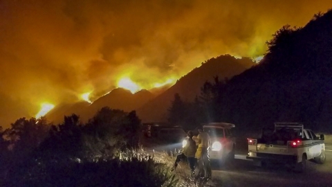 A fire sweeps across a mountainside