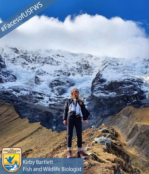 A girl with a camera stands on top of a mountain. A banner reads "#FacesofUSFWS". Another banner reads "Kirby Bartlett, Fish and Wildlife Biologist