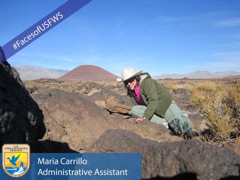 A woman sits on top of large rocks