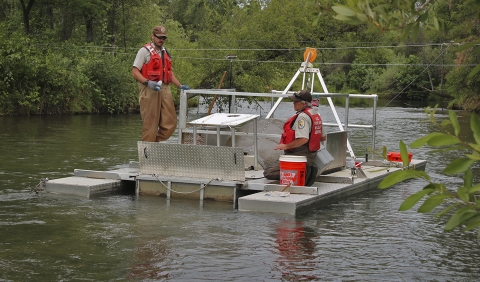 two people on a metal barge in a river