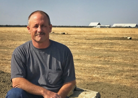 Man sitting in a field facing camera