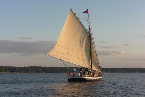 Sunset lights up the full sail of an 18th century schooner