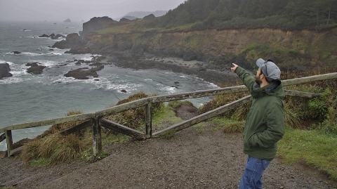 a man pointing at the ocean