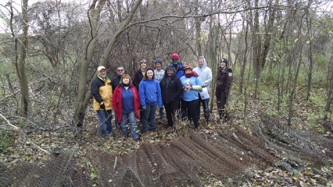 A work team poses in the woods. 