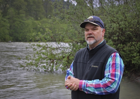 a man standing next to a river