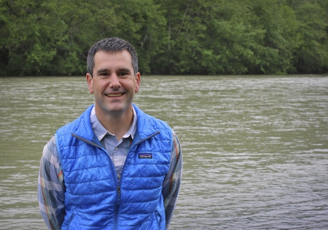 a man standing next to a river