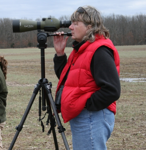 A person looking through a spotting scope. 