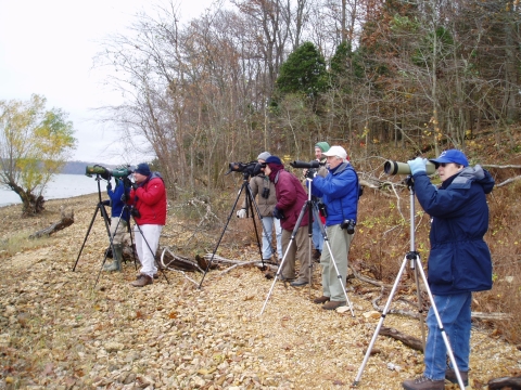 A group of people looking through spotting scopes.