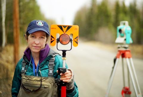 woman holding survey equipment