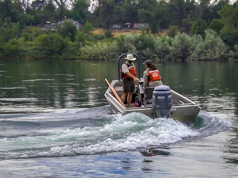 two people in a boat on a river.