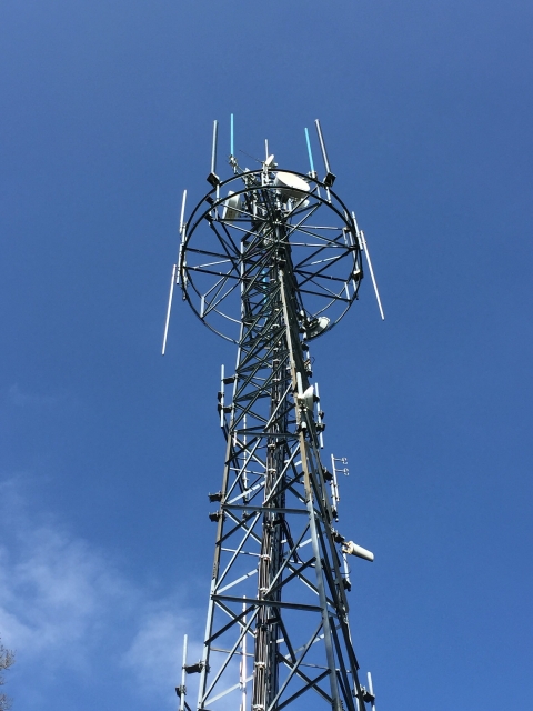 A cellular phone tower against a blue sky