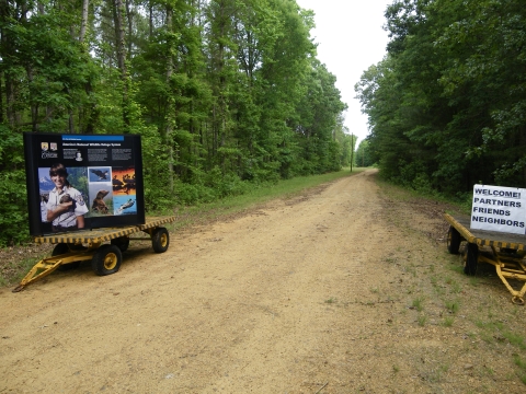 Dirt road with welcome signs