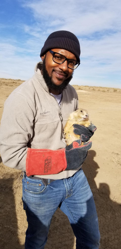 Man holds a prairie dog.