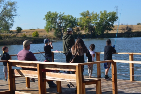 Visitors casting a fishing line at Lake Mary pier