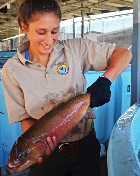 a woman holding a large fish