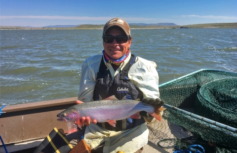 a man in a boat holding a fish