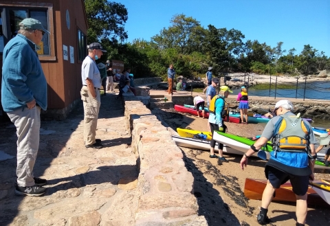 Kayakers are greeted by USFWS volunteers as they land by the education pavilion at the Outer Island Unit, Branford