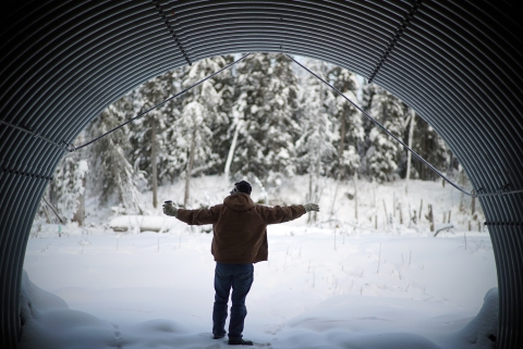 man standing in a large arch culvert