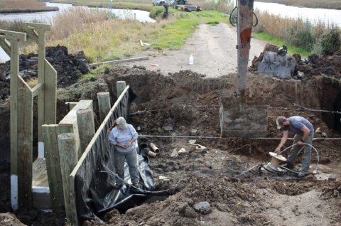 Two people working in a construction hole.