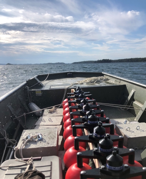 The bow of a boat carrying red plastic acoustic equipment.