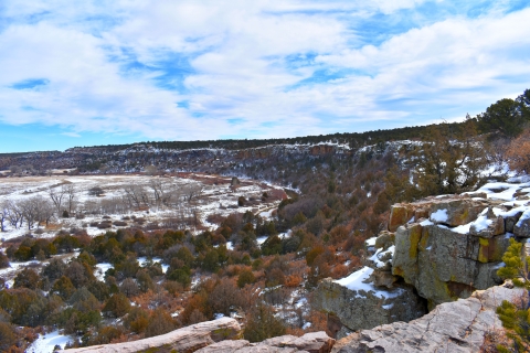 A rocky, evergreen tree-covered landscape under a dusting of snow