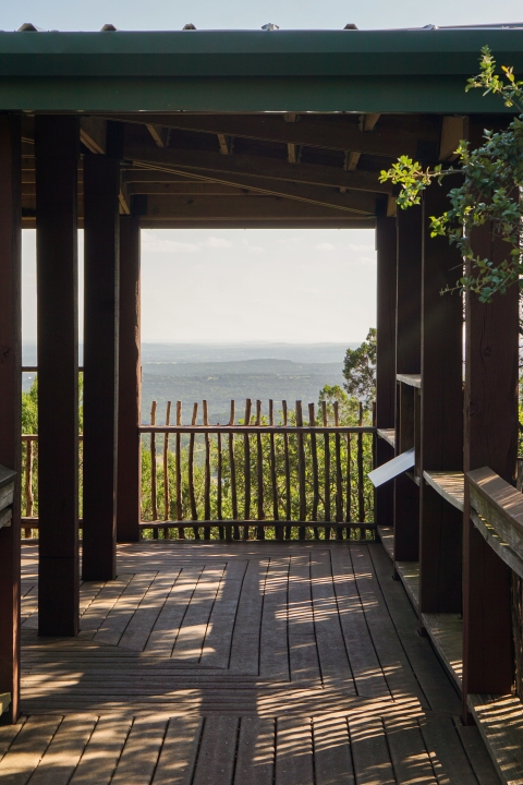 A deck overlooks a scenic view of hills