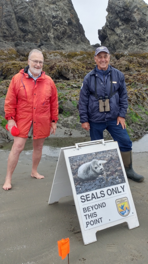 A refuge volunteer and visitor on the rocky shoreline of Oregon