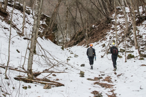 Two people walk along a trail through a snow-covered landscape