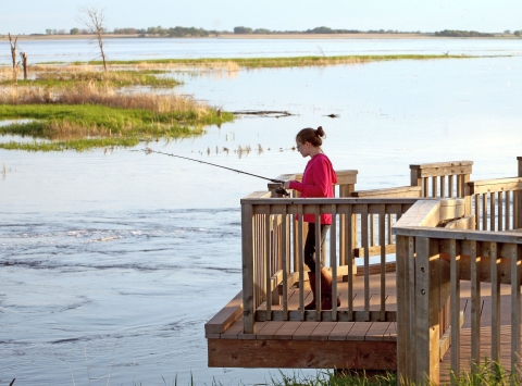 A young woman fishing from a platform