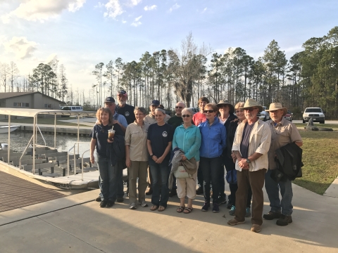 Group of people standing on the sidewalk getting ready for a boat tour